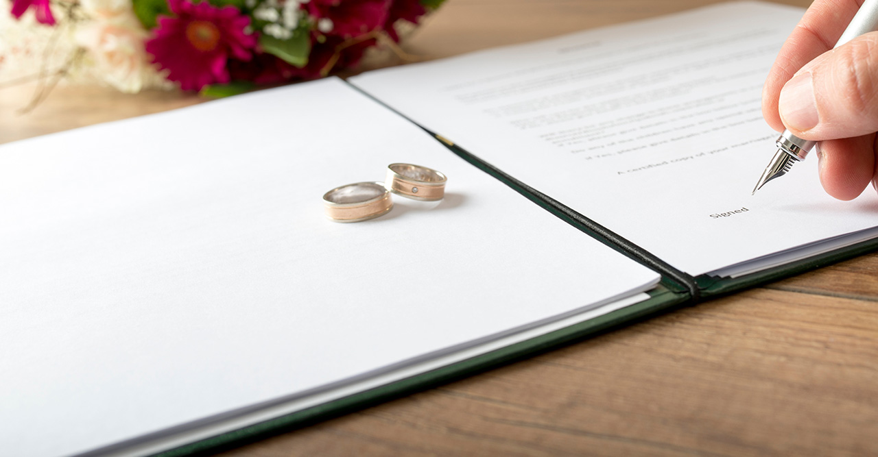 man signing a marriage register