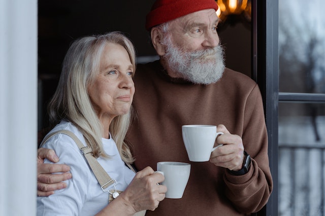 smiling older couple holding coffee