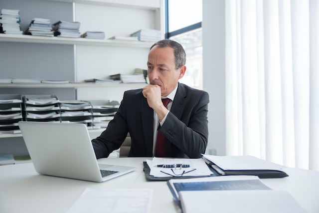 man with papers and computer