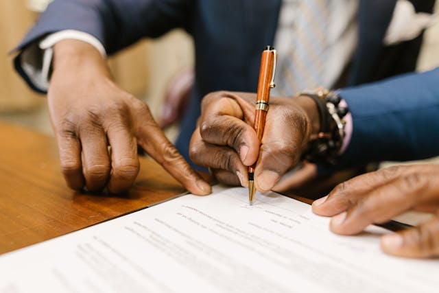 man showing person where to sign on document