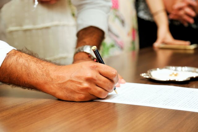 man signing document